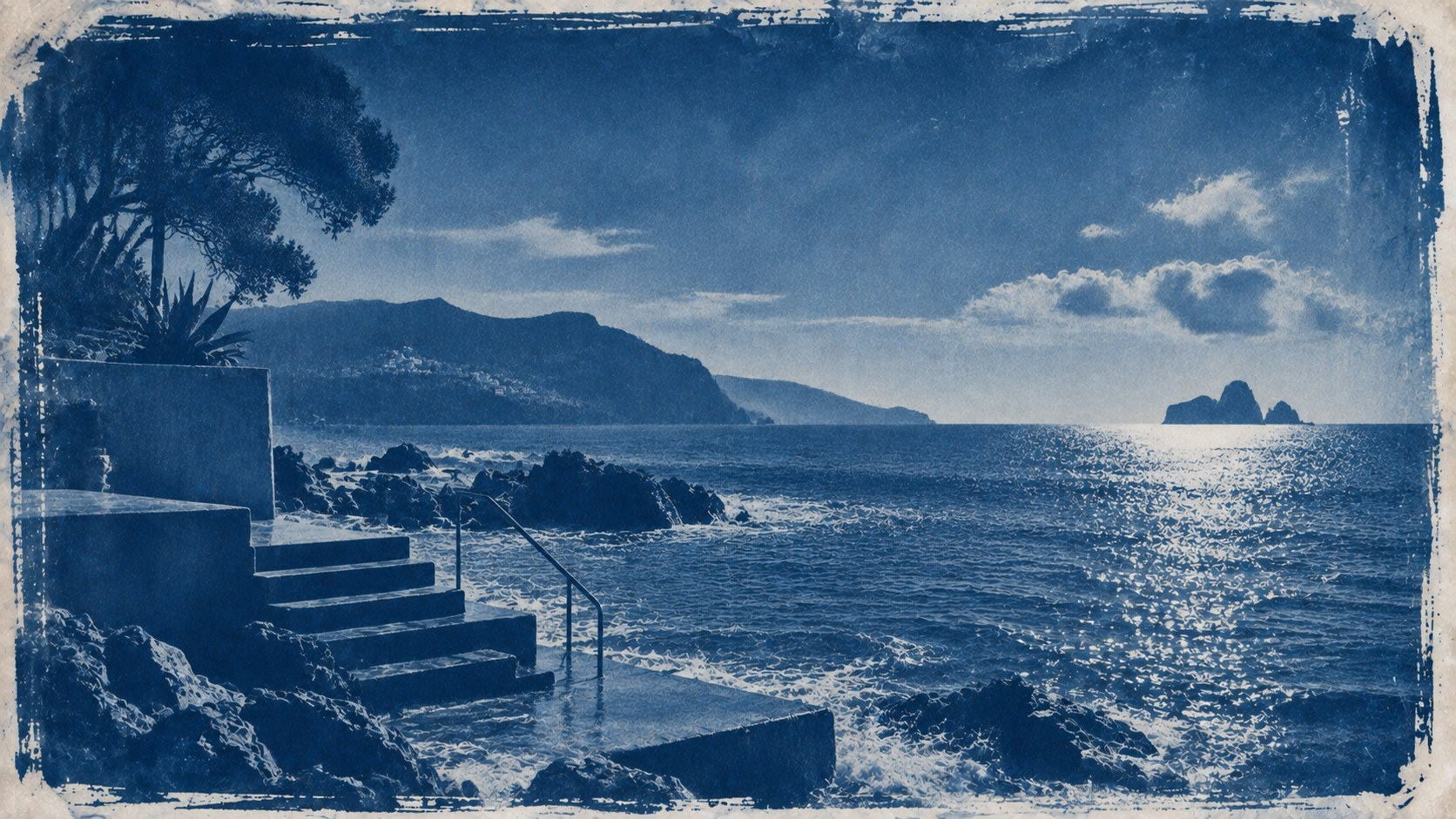 Concrete steps and a handrail running down into the sea on a rocky coast, sunlight on the water, printed as a cyanotype.