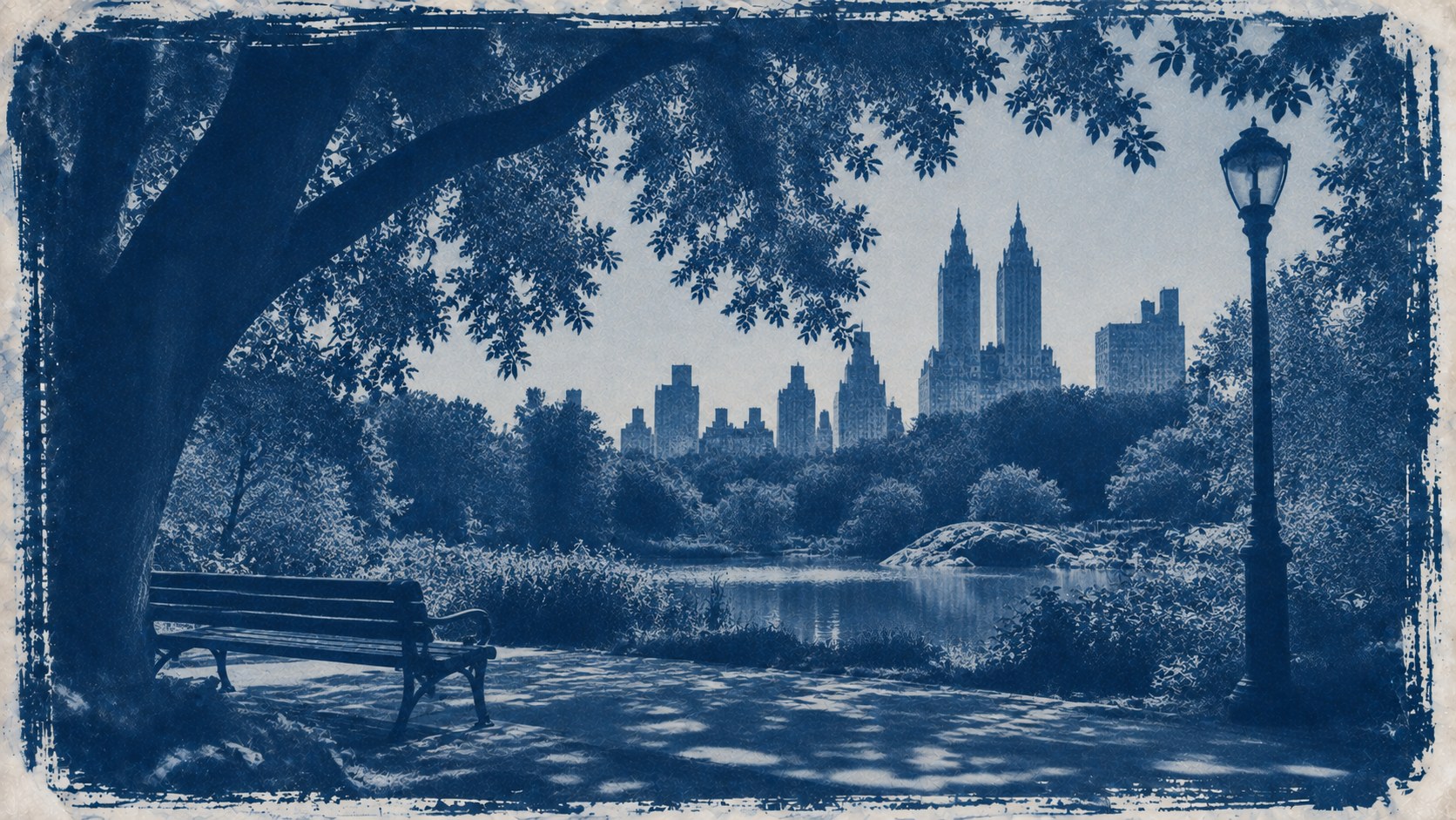 A park bench and lamppost under a spreading tree beside a pond, a twin-towered skyline beyond, printed as a cyanotype.