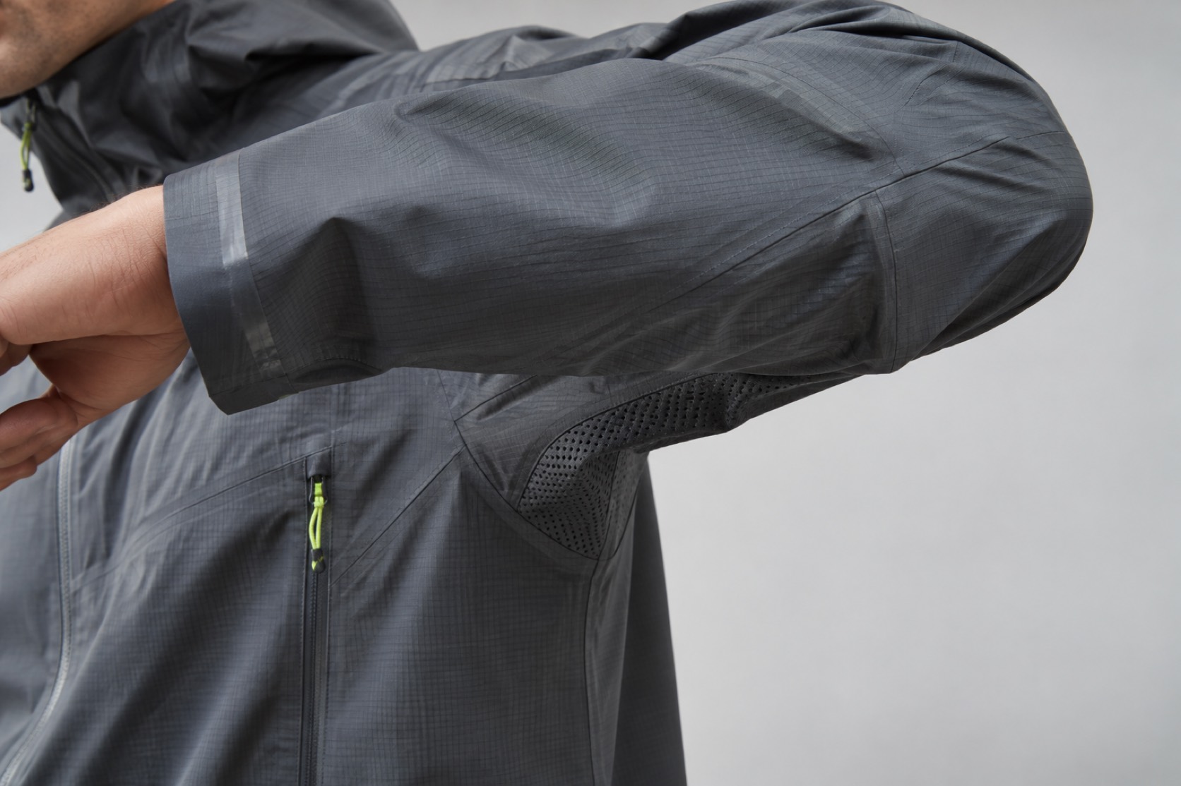 Close view of a bent shell-jacket sleeve, taped cuff and mesh underarm panel.