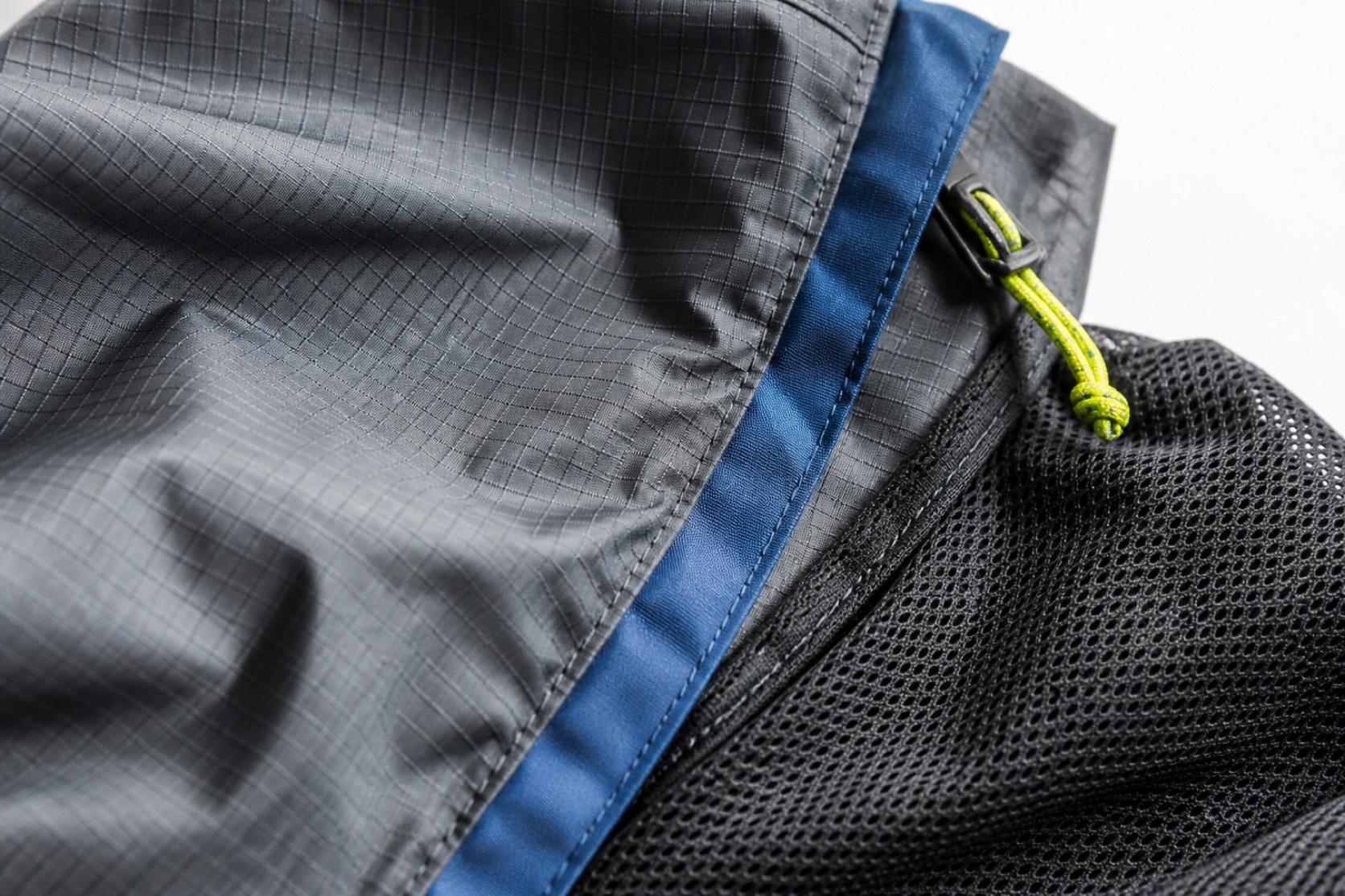 Ripstop, mesh and a cobalt seam strip reveal their contrasting textile structures.